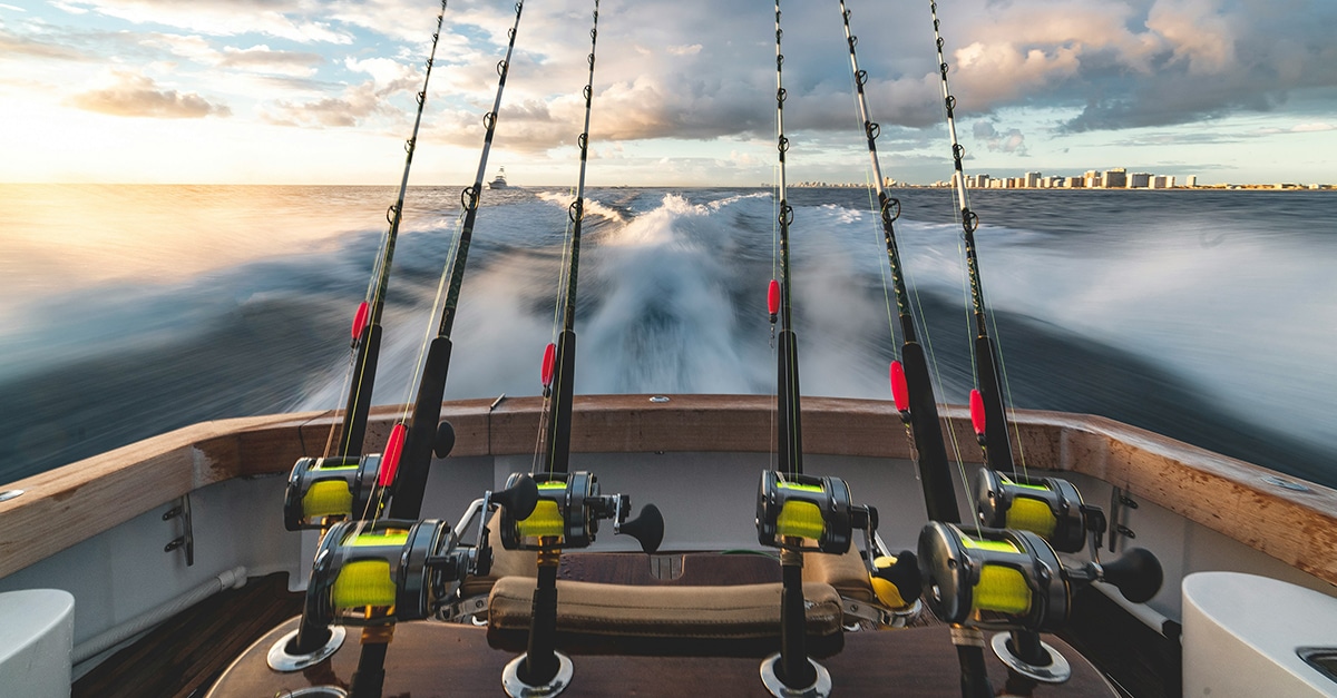 Six fishing poles mounted to the back of a motorized boat
